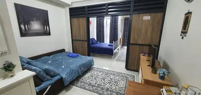 a small room with a bed and a living room at Hannah suite at cameronfair in Cameron Highlands