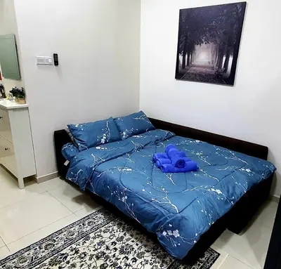 a bed with a blue teddy bear sitting on it at Hannah suite at cameronfair in Cameron Highlands