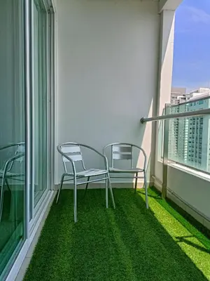 two chairs on a balcony with green grass at Mansion One 3 Bedroom SEAVIEW Gurney Georgetown 1-13Pax in George Town