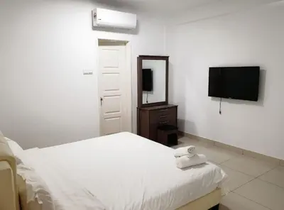a bedroom with a white bed and a television at Mansion One 3 Bedroom SEAVIEW Gurney Georgetown 1-13Pax in George Town