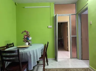 a dining room with a table and a green wall at HomestayMuslim Di Teluk Intan in Teluk Intan