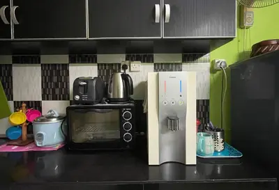 a kitchen counter with a microwave and a coffee maker at HomestayMuslim Di Teluk Intan in Teluk Intan