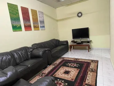a living room with a leather couch and a flat screen tv at HomestayMuslim Di Teluk Intan in Teluk Intan