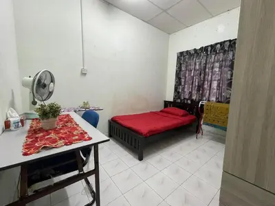 a small room with a red bed and a table at HomestayMuslim Di Teluk Intan in Teluk Intan