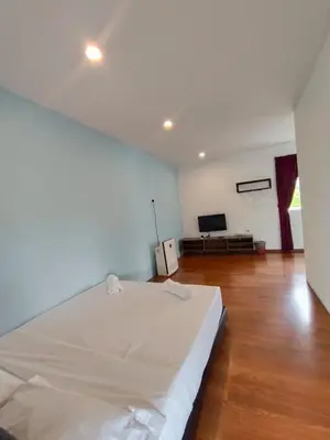 a bedroom with a large white bed and a flat screen tv at Dear Dino Villa Cameron Highlands in Cameron Highlands