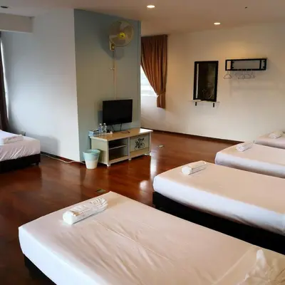 a room with two beds and a flat screen tv at Dear Dino Villa Cameron Highlands in Cameron Highlands