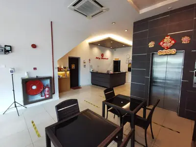a dining room with a table and chairs and a tv at My Hotel Bukit Mertajam in Bukit Mertajam