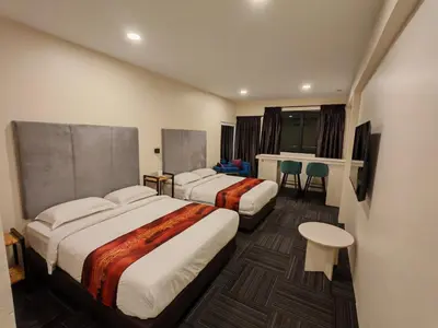 a hotel room with two beds and a table at Pangkor Pop Ash Hotel in Pangkor
