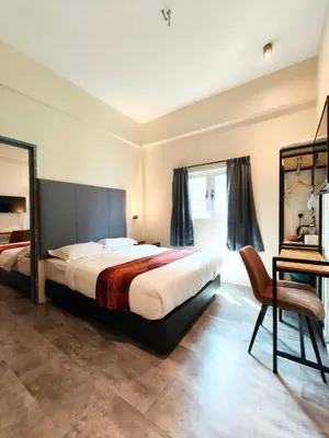a bedroom with a bed and a mirror and a chair at Pangkor Pop Ash Hotel in Pangkor