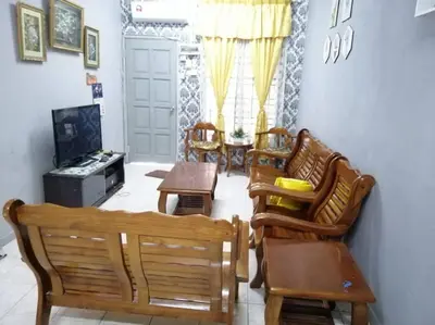 a living room with wooden chairs and a table at HOMESTAY PERPADUAN, TAMAN BERCHAM RAYA ULU KINTA IPOH PERAK in Kampong Batu Lapan
