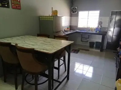 a kitchen with a table and some chairs and a refrigerator at HOMESTAY PERPADUAN, TAMAN BERCHAM RAYA ULU KINTA IPOH PERAK in Kampong Batu Lapan