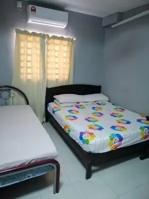 a bedroom with a bed and two windows and a bedskirts at HOMESTAY PERPADUAN, TAMAN BERCHAM RAYA ULU KINTA IPOH PERAK in Kampong Batu Lapan