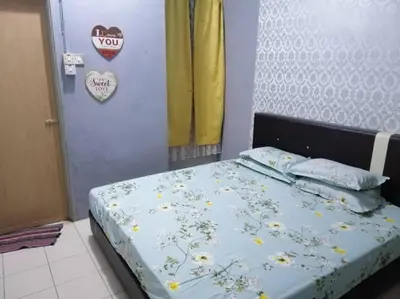 a bedroom with a bed with flowers on it at HOMESTAY PERPADUAN, TAMAN BERCHAM RAYA ULU KINTA IPOH PERAK in Kampong Batu Lapan