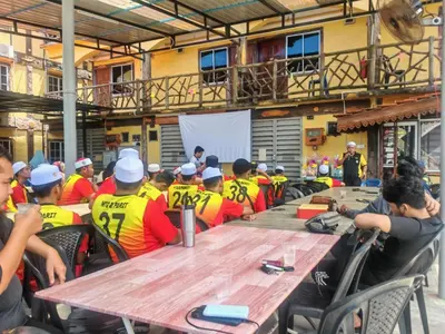 a group of people sitting around a wooden table at KAMILA MOTEL TELUK SENANGIN in Lumut