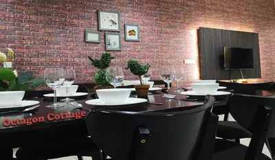a dining room with a table and chairs and a brick wall at H2H - Octagon Cottage at Ipoh Town Center in Ipoh