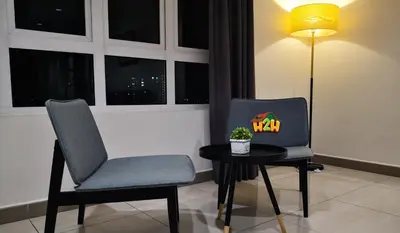 a chair sitting next to a table with a lamp at H2H - Octagon Cottage at Ipoh Town Center in Ipoh