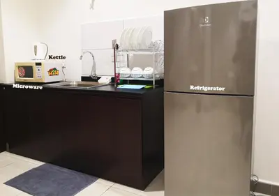a kitchen with a refrigerator next to a sink at H2H - Octagon Cottage at Ipoh Town Center in Ipoh