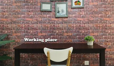 a brick wall with a table and a white chair at H2H - Octagon Cottage at Ipoh Town Center in Ipoh