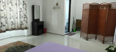 a living room with white floors and a room with a tv at Afamily Homestay in Ipoh