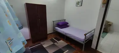a small bed in a room with a purple pillow at Afamily Homestay in Ipoh