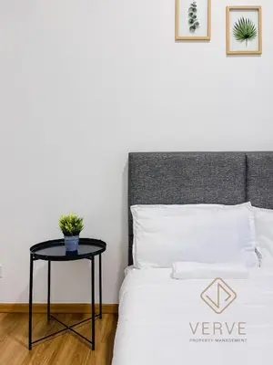 a bedroom with a bed with a table next to it at Ipoh Cove Premium Suites by Verve in Ipoh