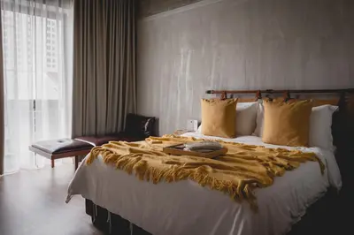 a bedroom with a large bed with a blanket on it at Hotel Mokozoyo in George Town