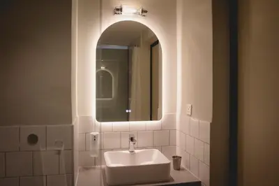 a white bathroom with a sink and a mirror at Hotel Mokozoyo in George Town