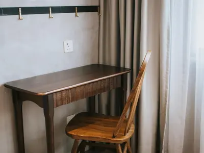 a wooden table with a chair next to a curtain at Hotel Mokozoyo in George Town