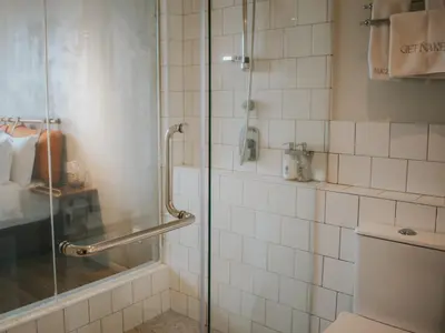 a bathroom with a shower with a glass door at Hotel Mokozoyo in George Town
