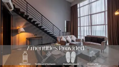 a living room with a staircase with a couch and a chair at Loft Pano Seaview Suite 2 Bedroom by The Only Bnb in Jelutong