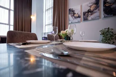 a dining room table with plates and wine glasses at Loft Pano Seaview Suite 2 Bedroom by The Only Bnb in Jelutong