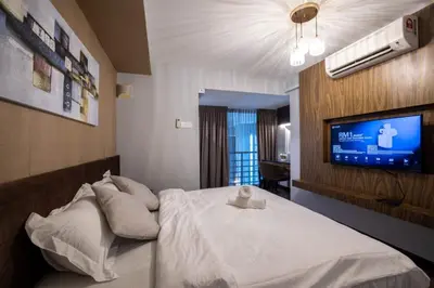 a bedroom with a bed with a tv on the wall at Loft Pano Seaview Suite 2 Bedroom by The Only Bnb in Jelutong