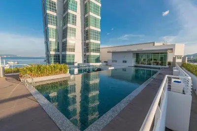 a building with a swimming pool in front of a building at Loft Pano Seaview Suite 2 Bedroom by The Only Bnb in Jelutong