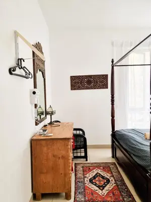 a bedroom with a bed and a dresser with a mirror at Mossy Forest Family Retreat, Kea Farm Brinchang in Brinchang