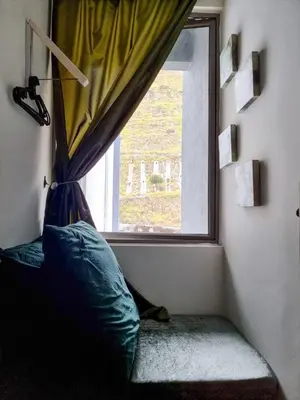 a window with a curtain and a pillow in a room at Mossy Forest Family Retreat, Kea Farm Brinchang in Brinchang