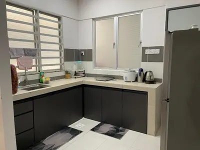 a kitchen with black and white counters and a refrigerator at Cameron Lavender Homestay 3 in Tanah Rata