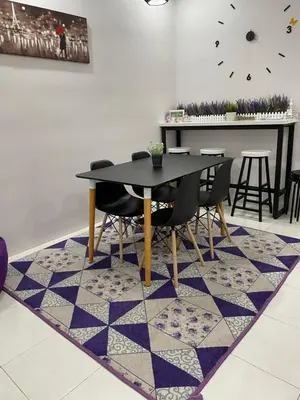 a dining room with a table and chairs on a rug at Cameron Lavender Homestay 3 in Tanah Rata