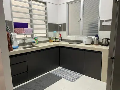 a kitchen with black cabinets and a sink and a window at Cameron Lavender Homestay 3 in Tanah Rata