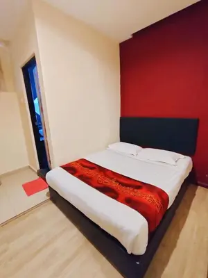 a bedroom with a large bed with a red wall at HOTEL YTS in Brinchang