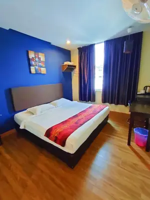 a bedroom with a large bed with blue walls at HOTEL YTS in Brinchang