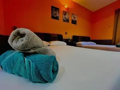 a stuffed animal is sitting on top of a bed at Kejora Garden Resort Pulau Pangkor in Pasir Bogak