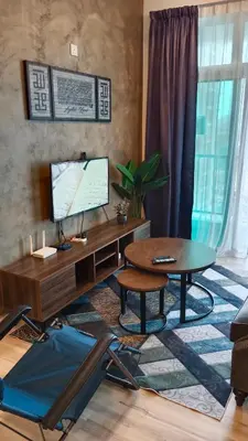 a living room with a desk with a computer and a table at Muslim Apartment at Meru in Ipoh