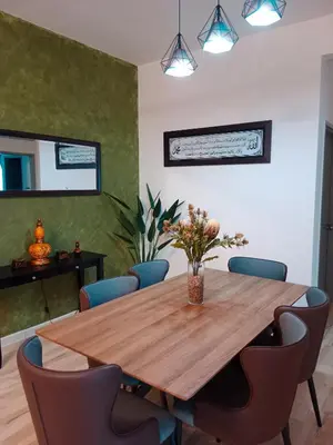 a dining room with a wooden table and chairs at Muslim Apartment at Meru in Ipoh