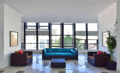 a living room with a blue couch and some windows at The Landmark Penang in Tanjong Tokong
