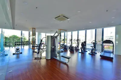 a gym with cardio equipment in a building with windows at The Landmark Penang in Tanjong Tokong