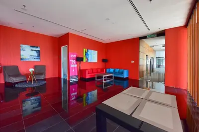a living room with red walls and a table and chairs at The Landmark Penang in Tanjong Tokong