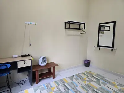 a room with a desk and a mirror and a table at The Simplicity Homestay in Tanah Rata