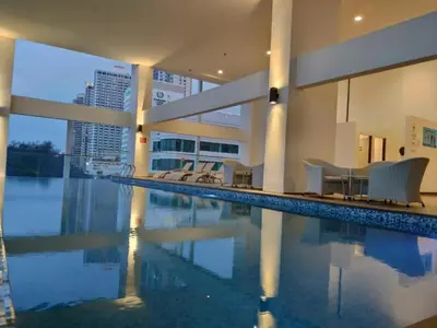 a swimming pool with chairs in a building at Sunrise Gurney Premium Executive City/Seafront suite - Penang in George Town