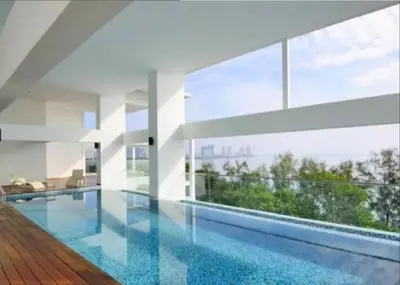 a large swimming pool in a house with glass walls at Sunrise Gurney Premium Executive City/Seafront suite - Penang in George Town