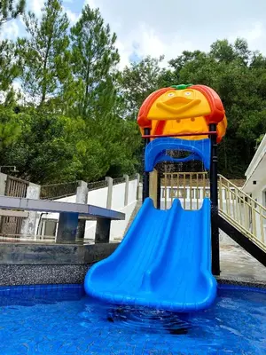a water slide in the middle of a swimming pool at 50PAX 9BR Villa Kids Swimming Pool, KTV, BBQ n Pool Tables near SPICE Arena Penang 9800 SQFT in Bayan Lepas